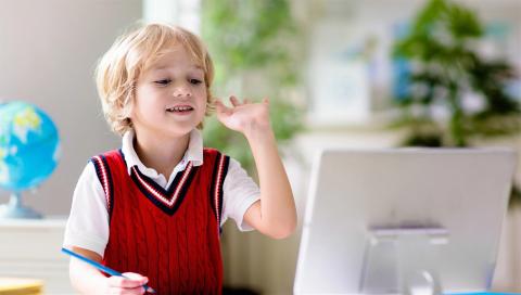 Elementary student with hand raised during video chat