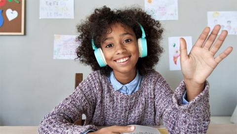 Middle school student waves to virtual classmates