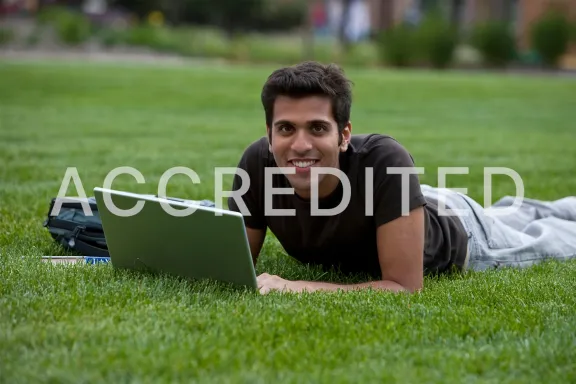 High school student studying for his online CMASAS courses on a blanket outside.